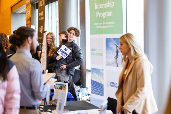 Student holding #HireHuskies sign at UW Career Fair