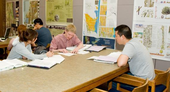 Students seated at a table conducting research in a library