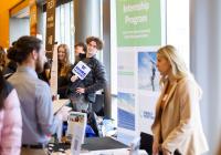 Student holding #HireHuskies sign at UW Career Fair