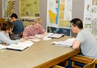 Students seated at a table conducting research in a library