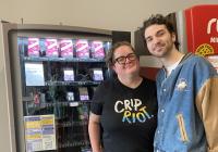 Kels and Toby Gallant from the Student Disability Commission stand together to the right of the emergency contraception vending machine located on the first floor of Odegaard Library in the cafe section