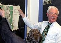 Richard Morrill holding a map while speaking to a class
