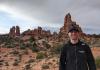 Mike Mamic stands in front of a desert landscape at Arches National Park