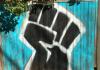 Raised fist, a universal symbol of solidarity and support. Artist Dave Savage.